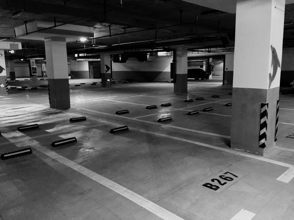 Parking de empresa vacío y ordenado con señalización clara y plazas disponibles